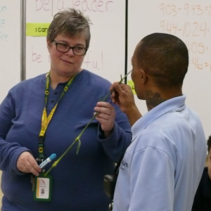 Elite Community Outreach volunteer working talking with student
